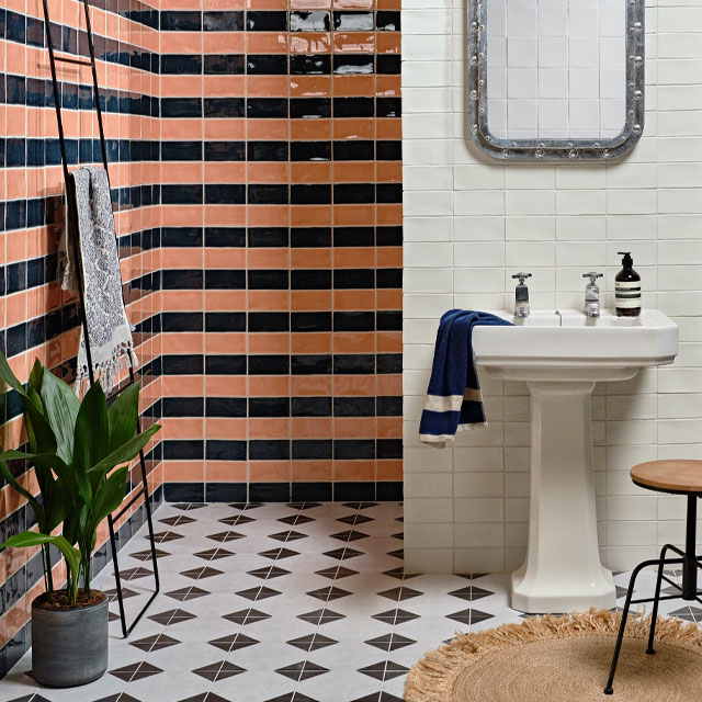 Recessed walk-in shower area with coral blush and black metro tiles on the wall and chequerboard floor tiles 