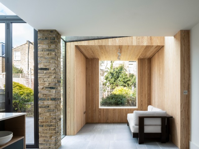 wood-clad snug seating area as part of a contemporary kitchen extension 
