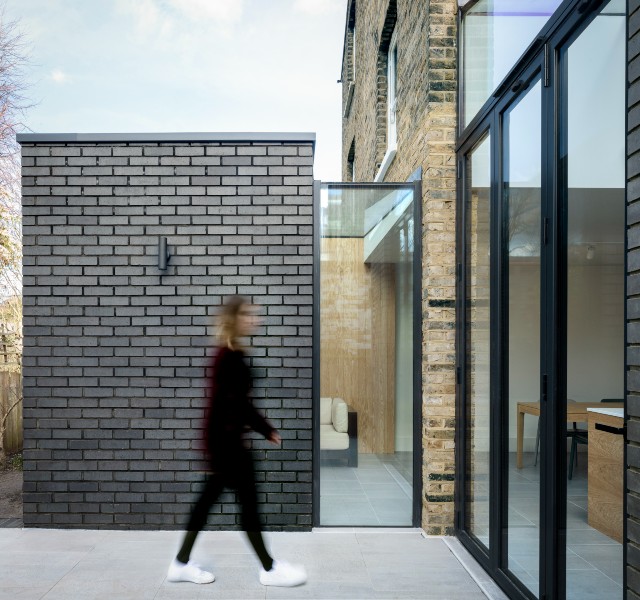 floor-to-ceiling bifold doors have opened up this dark kitchen to the light