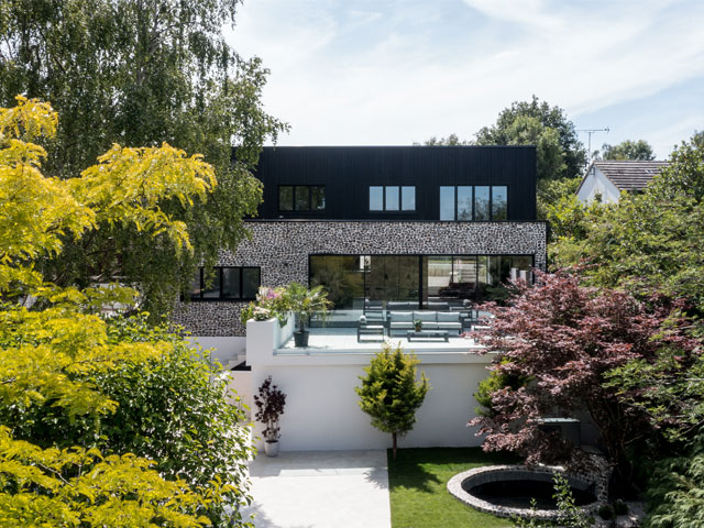 modular build in hertfordshire with flint and timber cladding and large sun terrace with views over the valley