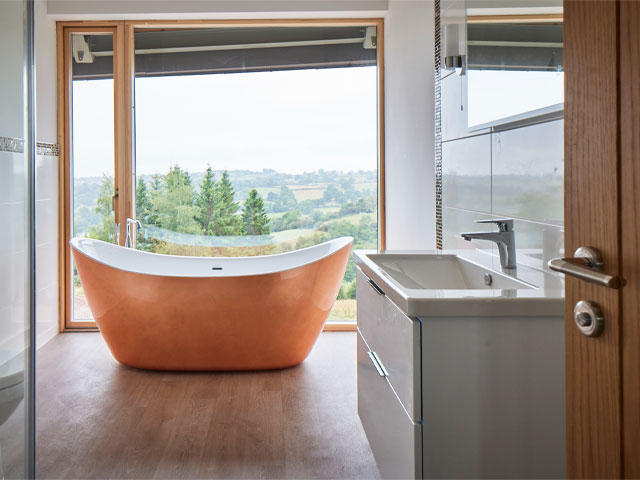 bathroom with floor-to-ceiling windows and a copper freestanding bathtub