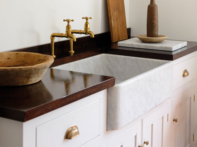 Cararra marble sink in farmhouse style with brass taps