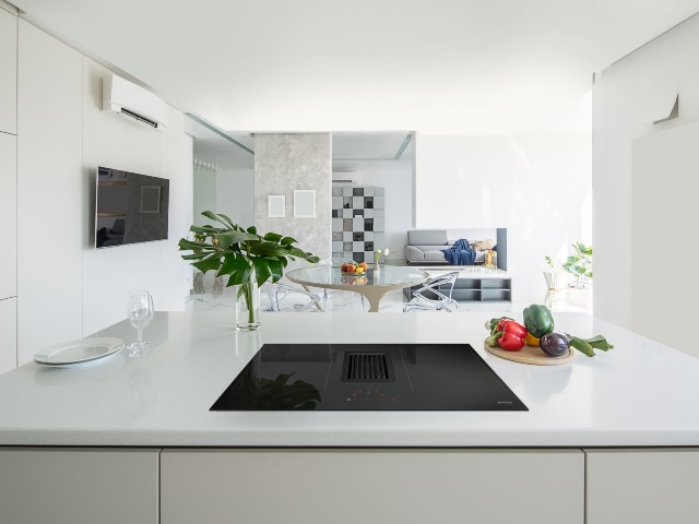 black integrated oven hob in a white, minimalist kitchen