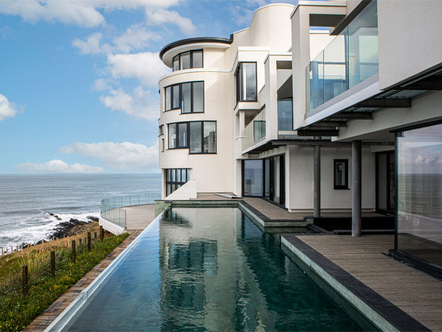 The Grand Designs Lighthouse with infinity pool and white-rendered rotunda