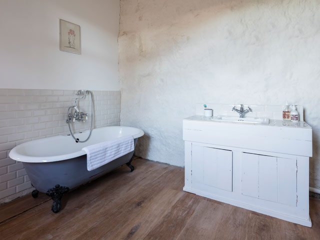 The rustic en suite bathroom with straw bale wall in the Grand Designs cowshed