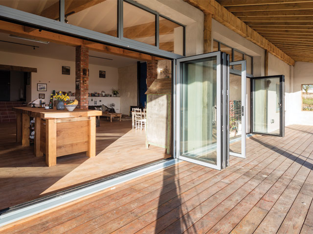 Aluminium bi-folding sliding doors open to the living space