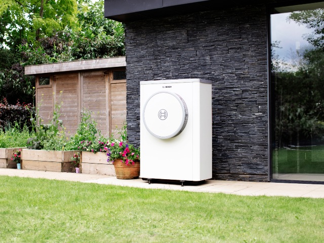 quiet heat pump outside a modern home with slate walls