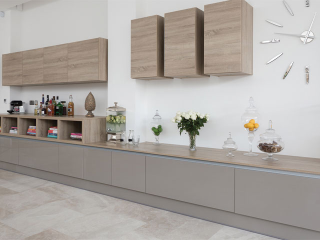 Modern grey kitchen with gloss cabinets and warm wooden shelving