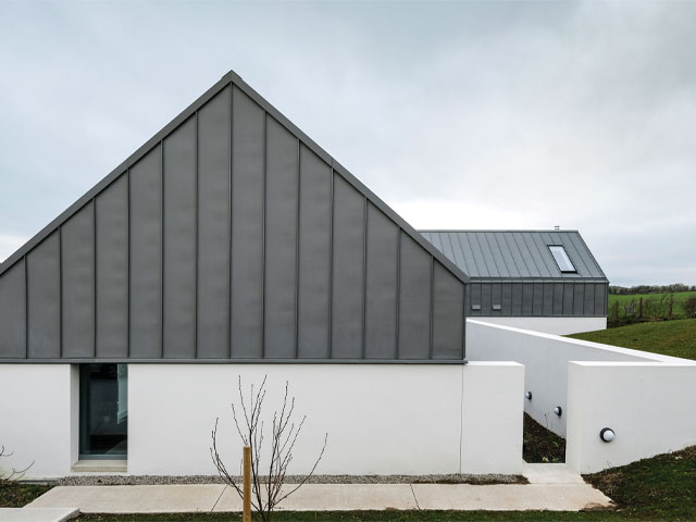 barn conversion with grey sheet cladding and white rendered walls