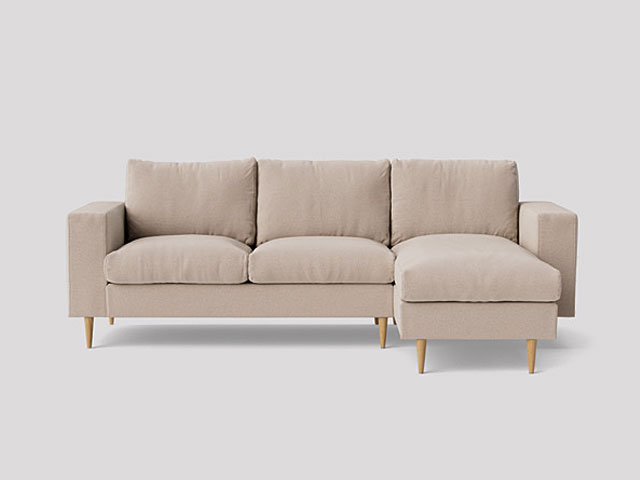 plaster pink/beige corner sofa with light wooden tapered legs on a white background