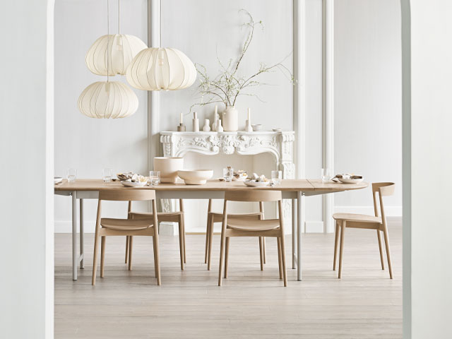 large oval dining table with scandi-style chairs in a large period dining room 