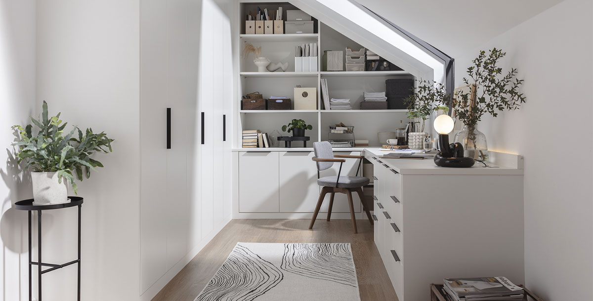 office in a loft extension with skylight window, white furniture and built-in wardrobes