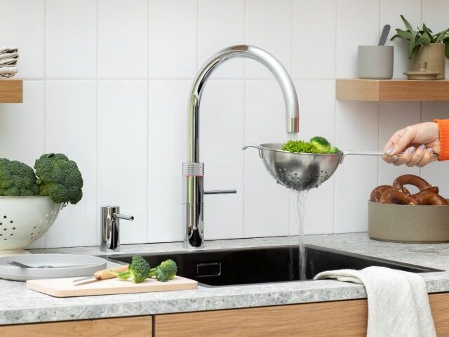 Rinsing vegetables in cold water from a Quooker tap in a contemporary kitchen 
