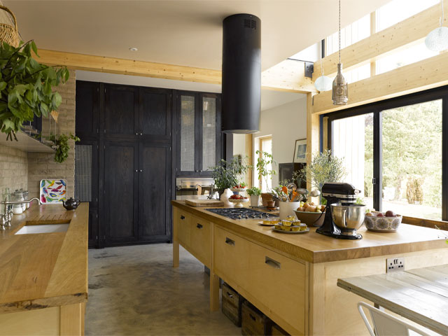 large kitchen with timber island, wooden worktops and exposed timber beams