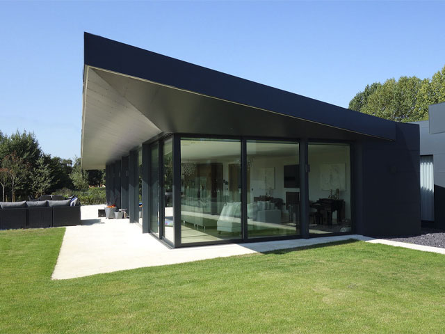 modern self-build house with angular cantilevered roof and large swathes of glass