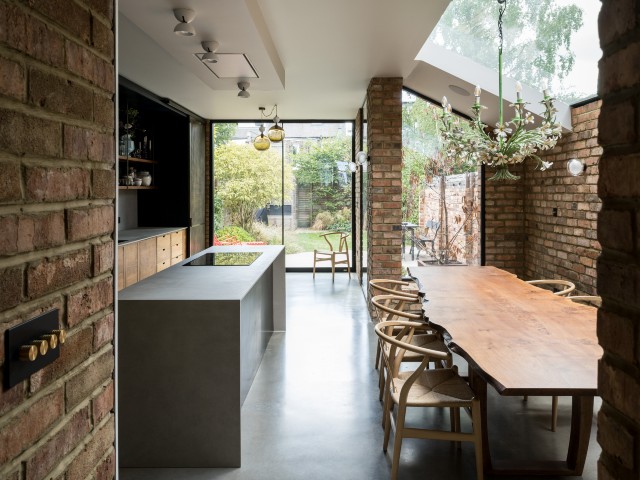 kitchen extension with exposed brick walls, lots of glazing and large wooden dining table with waney edges