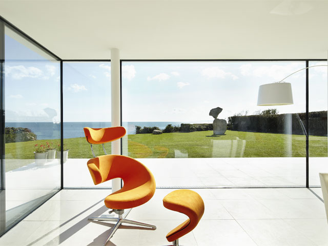 The bright orange Peel chair in the living room is a piece of functional art. This is mirrored by the balancing rock sculpture in the garden designed by Adrian Gray, Photo: Andrew Wall