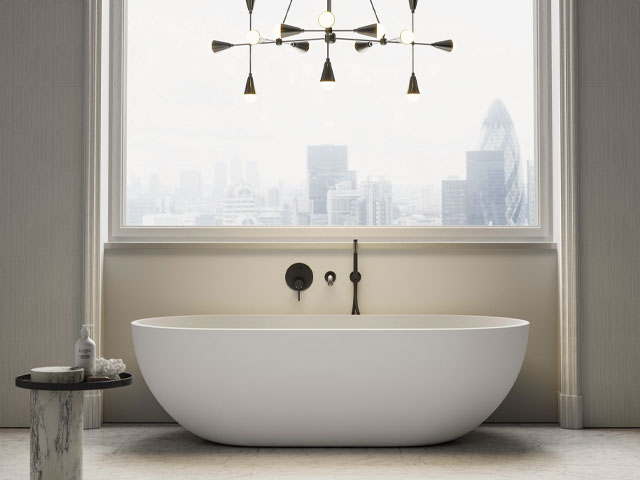 freestanding stone bath in a luxury penthouse bathroom with modern black taps and chandelier