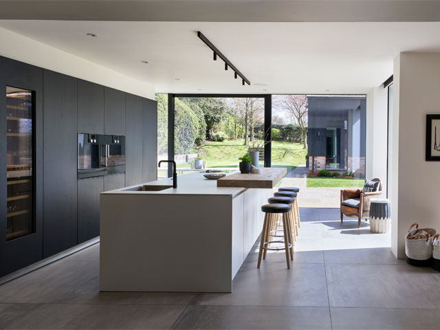 A single storey kitchen extension black-grey oak and kaolin with stained oak breakfast bar 