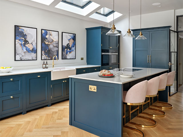 Hand painted Shaker kitchen with walnut veneer cabinet interiors and Carrara Venato worksurfaces. Bigger and brighter kitchens.