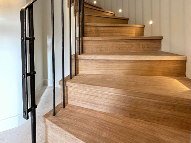 modern black metal stair bannister on curved wooden staircase