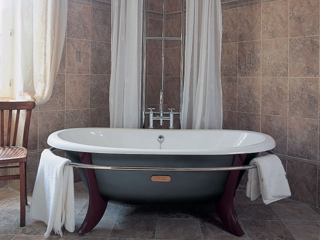 Cantered blue bathtub with towel rail in stately home bathroom