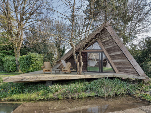 The Climbers Cabin exterior with decking in front of stream. 