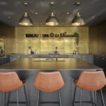 mixed metal industrial pendant lights in a black and gold kitchen