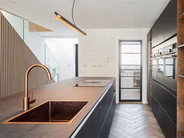 Modern bathroom with copper fixtures and fittings with herringbone floor and crittal door