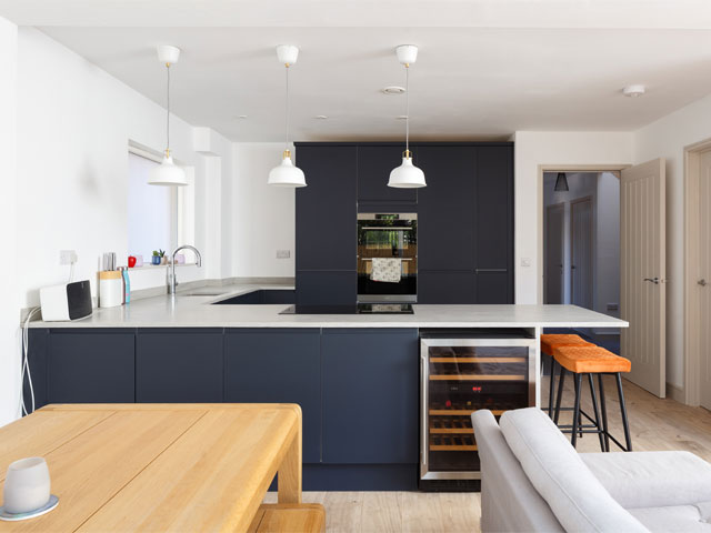 Blue kitchen white marble surfaces modern oven wine fridge white pendant lights