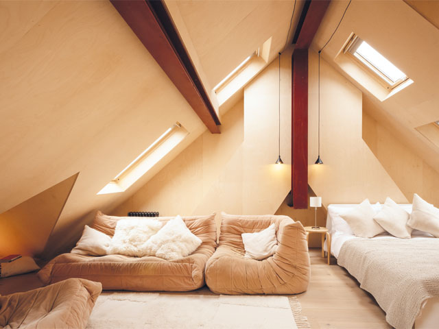 Hove-Photo-Jim-Stephenson. beige coloured loft room deep red steel beams low sofa white bed