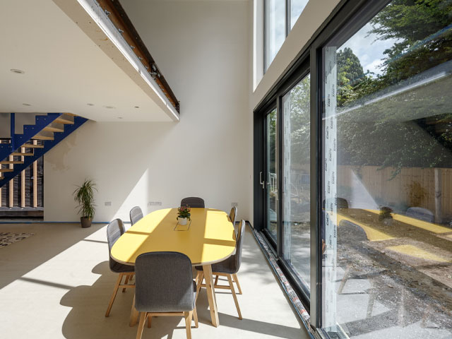 Grand Designs: The Streets. Yellow dining table grey chairs mezzanine glass patio doors