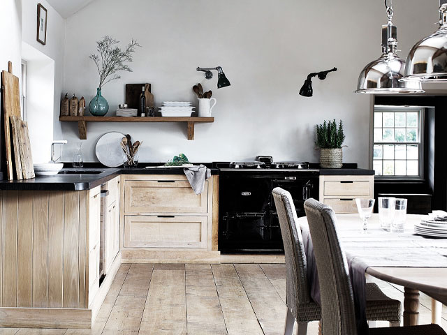 Kitchen layout Wood flooring wooden cabinets white walls wooden shelving metallic hanging lights 