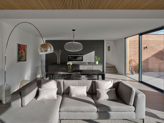handmade bricks home interior grey sofa black dining table polished concrete floor