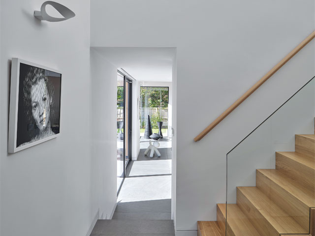 handmade bricks home interior wooden stairs glass balustrade black and white artwork with light above