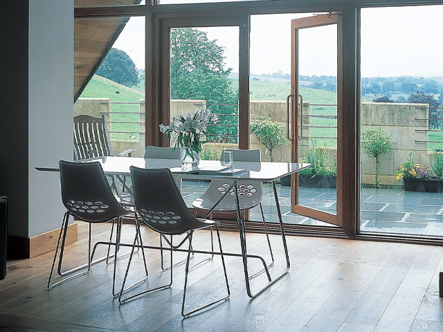 Grand Designs Hellifield Peel Castle. Balcony overlooking field. dining table on wood flooring