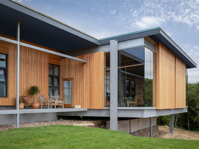 wooden cladding exterior of house steel beams overhang roof floor to glass ceiling
