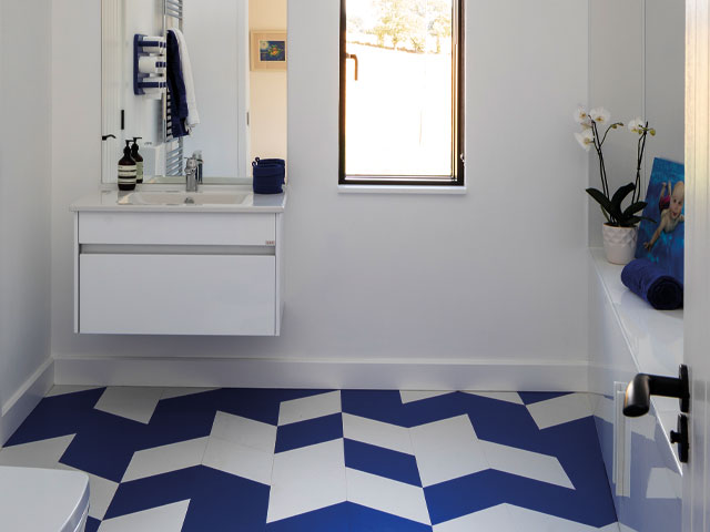Grand Designs Leominster. White bathroom floating white sink blue and white geometric floor tiles white lily