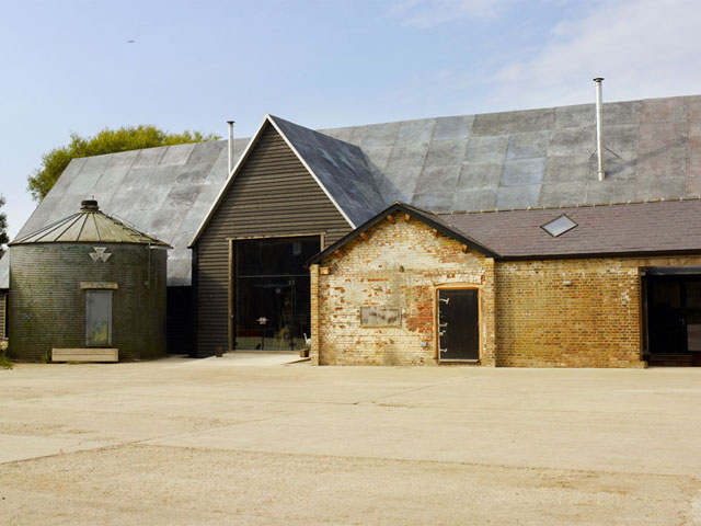 Barn exterior exposed brick dark green silo dark timber cladding 
