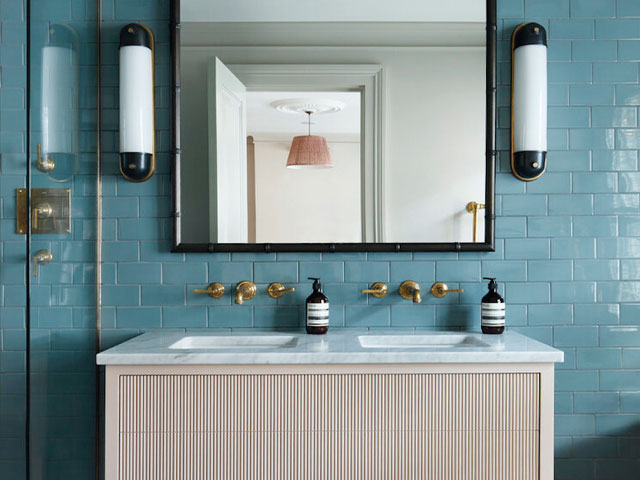 Blue tiled walls double sink unit wall mounted taps large black mirror white pill mirror lighting with black tips