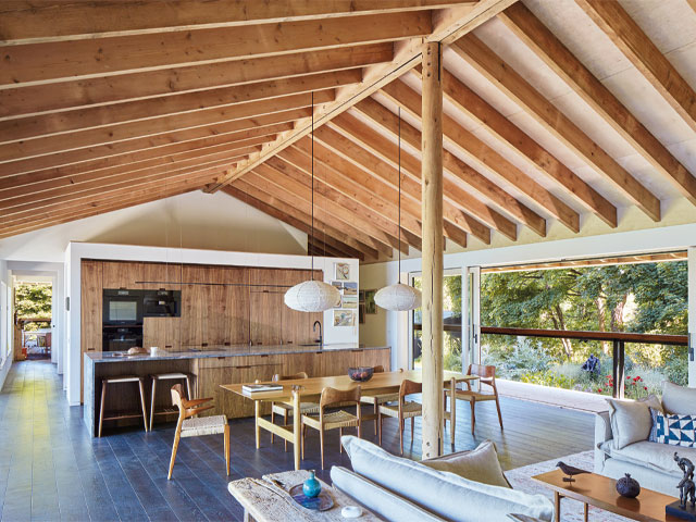open plan kitchen and dining area hanging pendant lights walnut cabinets exposed beam roof