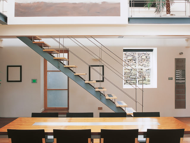Wooden dining table 8 chairs industrial stairs white walls