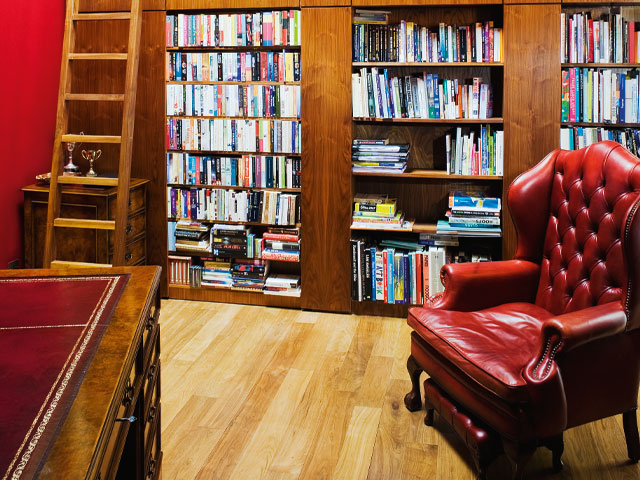 grand designs violin factory. Red leather reading chair in home library wooden executive desk ladder bookshelfs