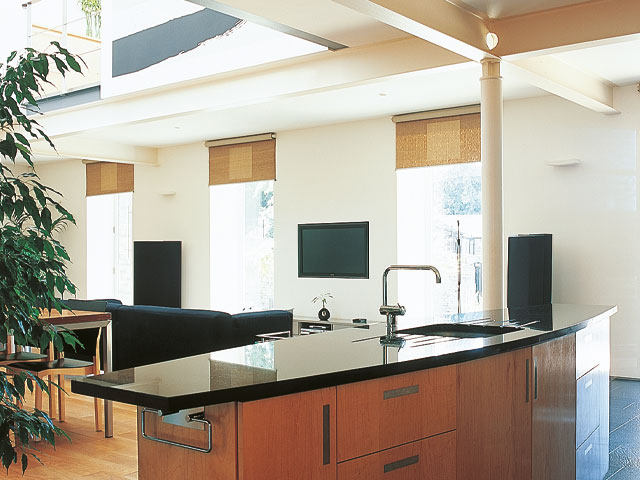 Grand Designs Huddersfield Mill Black kitchen worktop open plan living room blue sofa wall mounted television
