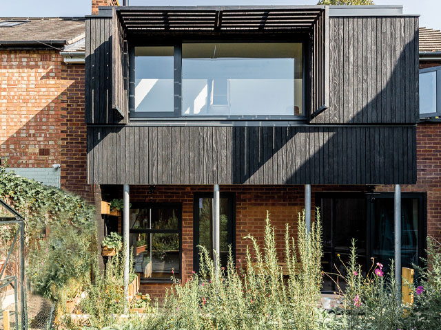 red brick house exterior with charred timber first floor wildflower garden