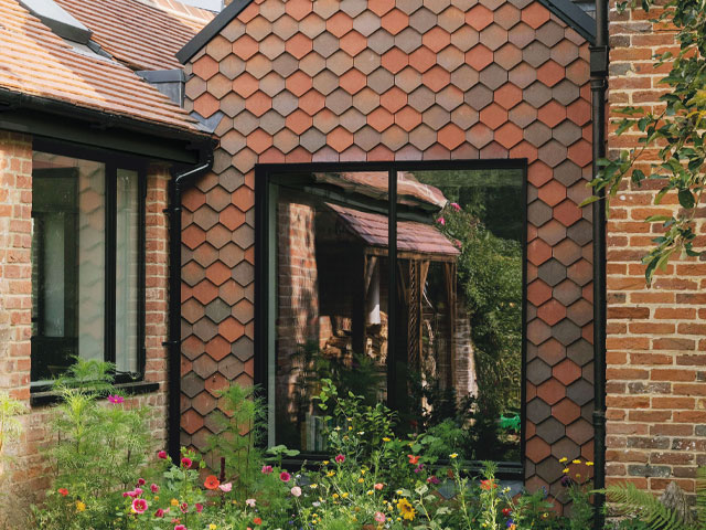 red tiles covered house with black window and door frame wildflower garden