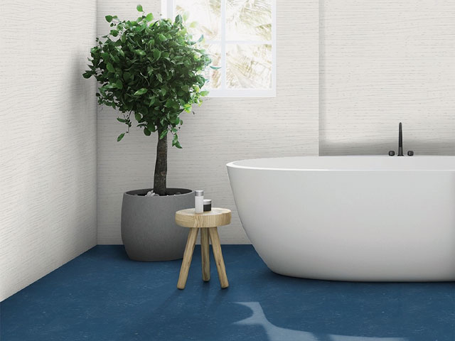 large white freestanding tub with dark blue flooring concrete plant pot holding small shrub