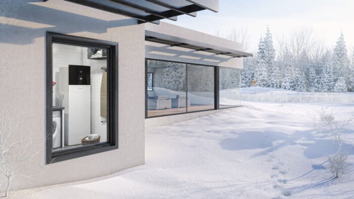 A ground-source heat pump visible through the window of a modern building in a snowy setting
