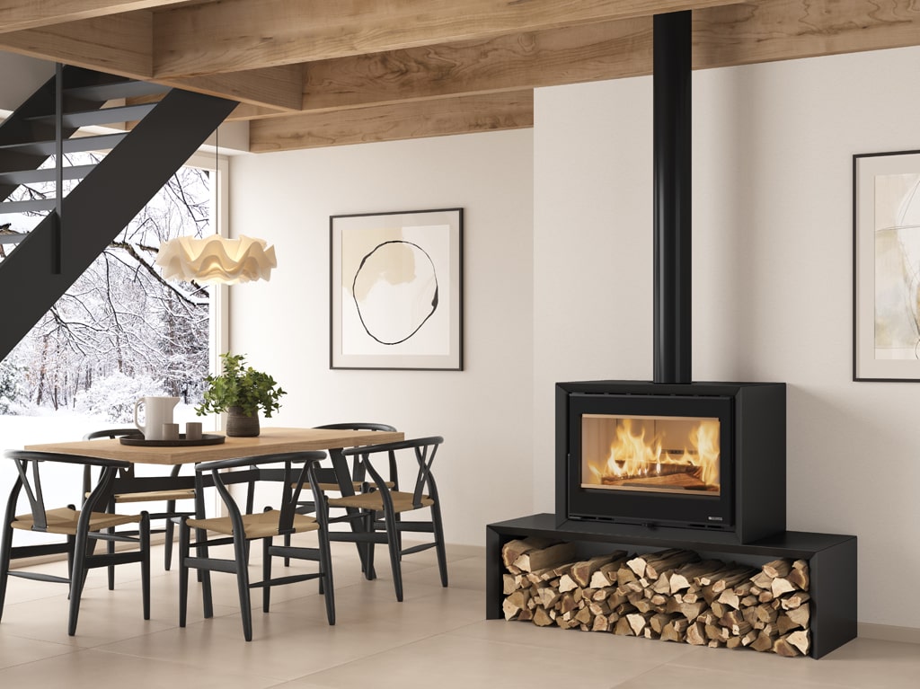 A wood stove in an open plan living room, with a snowy scene outside