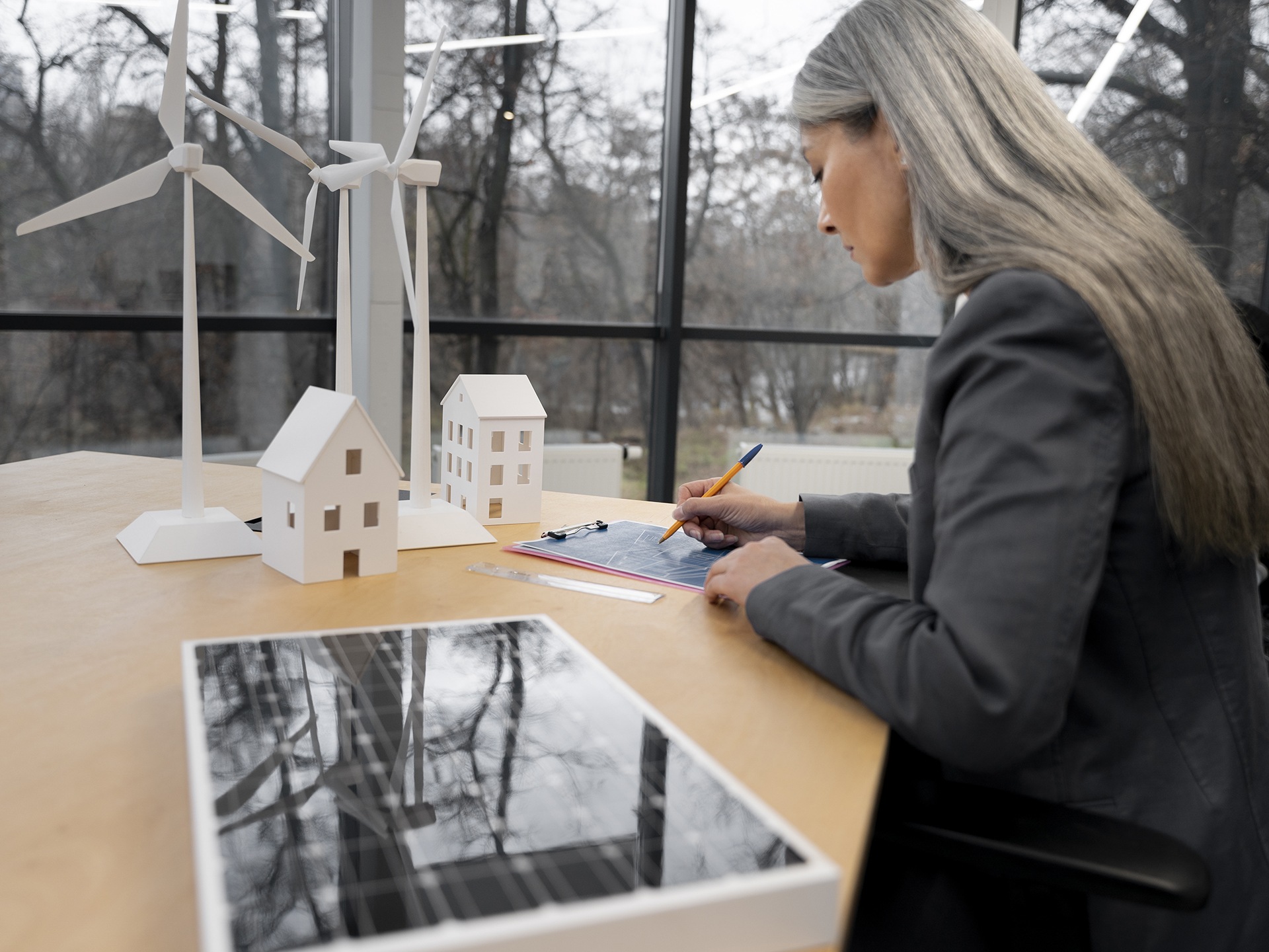 A woman looking at model of a building and making calculations